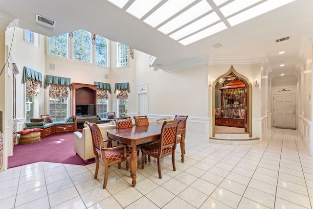 dining space with light carpet, a high ceiling, plenty of natural light, and ornamental molding