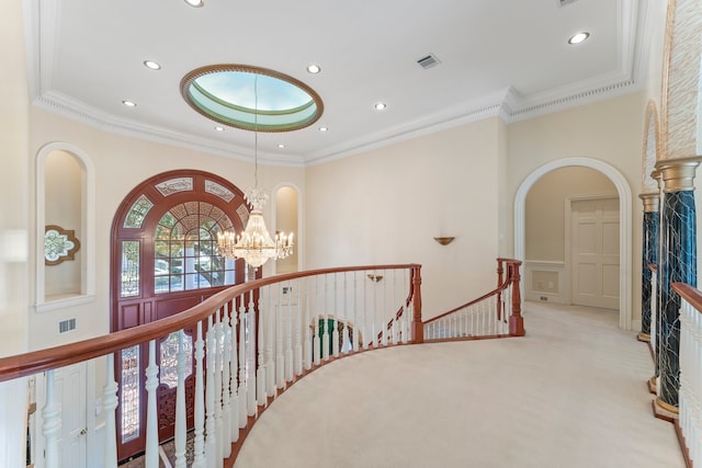 staircase with a chandelier, carpet flooring, and crown molding