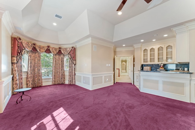 interior space with ceiling fan, ornamental molding, and light carpet