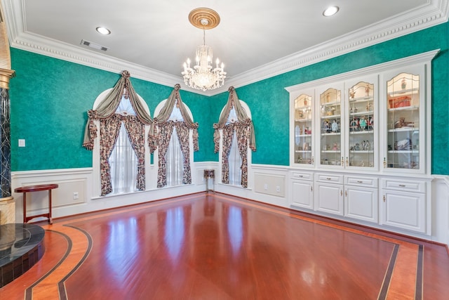 unfurnished dining area with crown molding and a chandelier