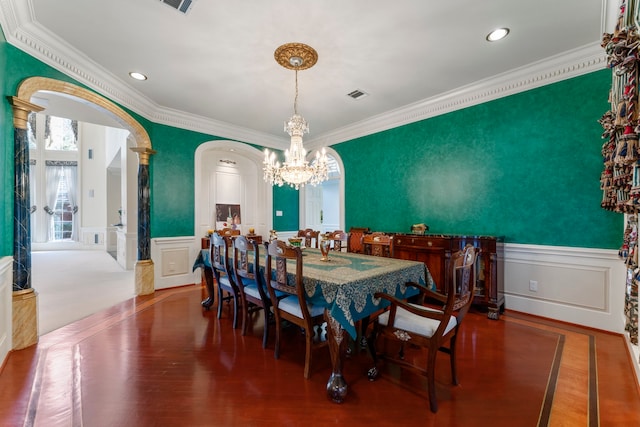 dining area featuring hardwood / wood-style floors, ornamental molding, and an inviting chandelier