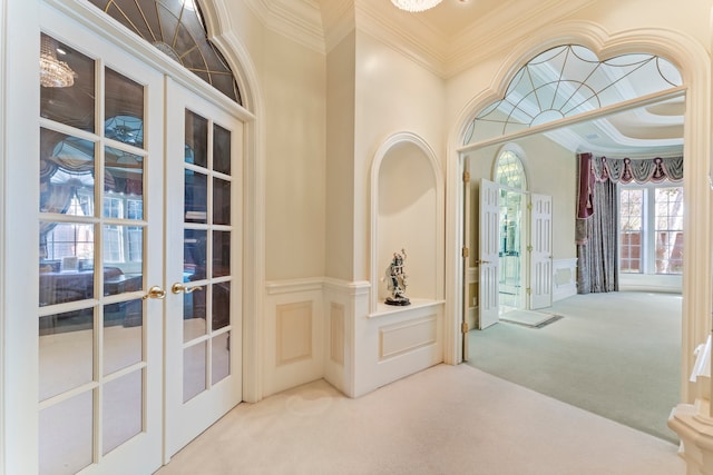 entrance foyer featuring crown molding, french doors, and carpet