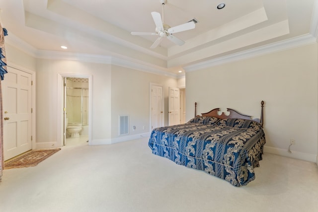 carpeted bedroom with ensuite bathroom, a raised ceiling, ceiling fan, and ornamental molding