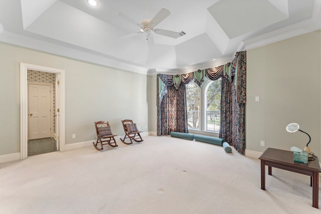 sitting room with a raised ceiling, ceiling fan, carpet, and ornamental molding