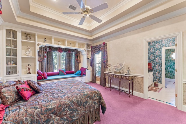 carpeted bedroom with a tray ceiling, ceiling fan, and ornamental molding