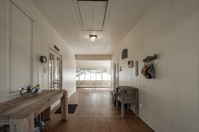 hallway with wooden walls, hardwood / wood-style floors, and french doors