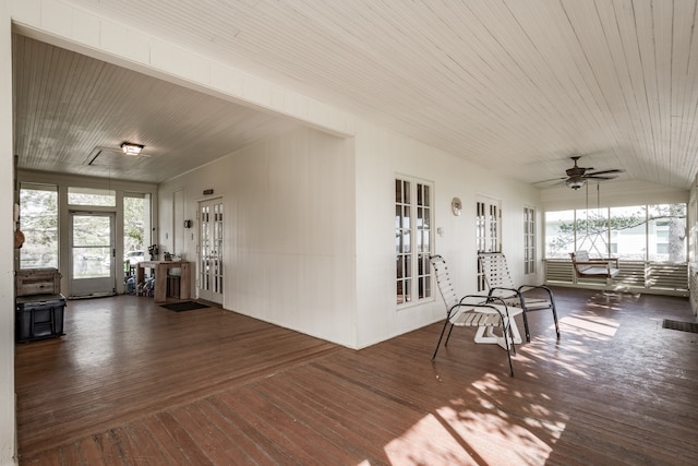 unfurnished sunroom featuring vaulted ceiling, ceiling fan, and a healthy amount of sunlight