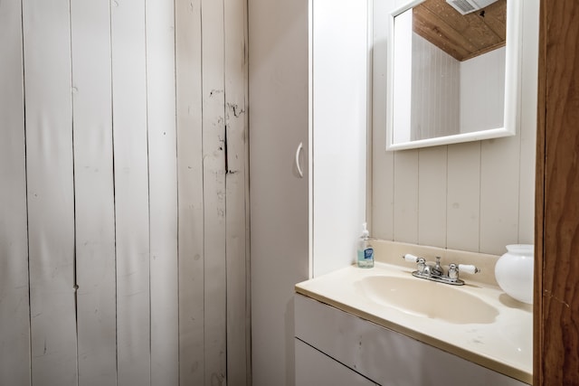 bathroom featuring vanity and wood walls