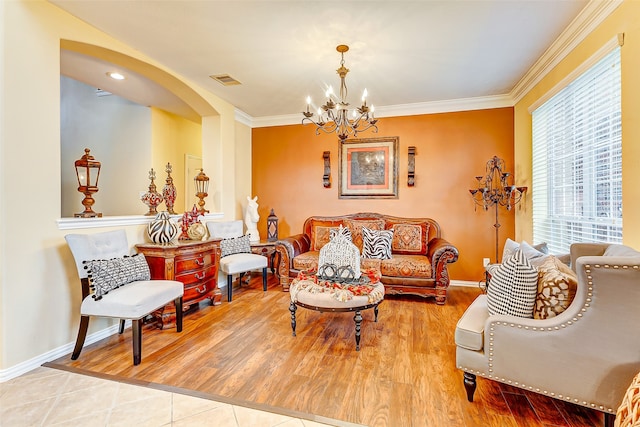 living room with hardwood / wood-style floors, crown molding, and a notable chandelier