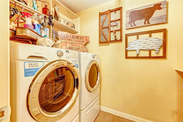 laundry area with washing machine and dryer and light tile patterned flooring