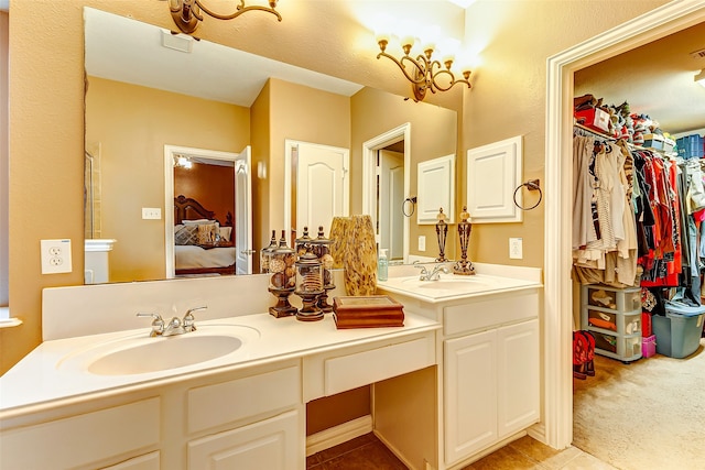 bathroom with tile patterned flooring, vanity, and a notable chandelier