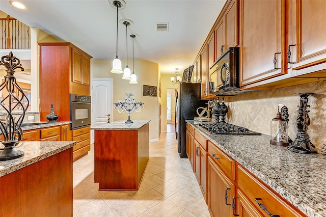 kitchen with a center island, light stone counters, appliances with stainless steel finishes, and tasteful backsplash