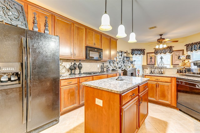 kitchen with ceiling fan, black appliances, light tile patterned floors, decorative light fixtures, and a kitchen island