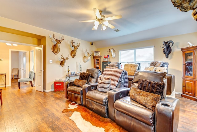 cinema with hardwood / wood-style floors and ceiling fan