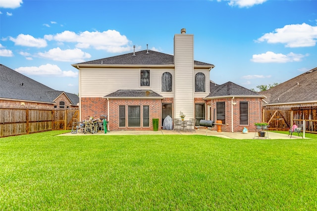 rear view of property with a yard and a patio