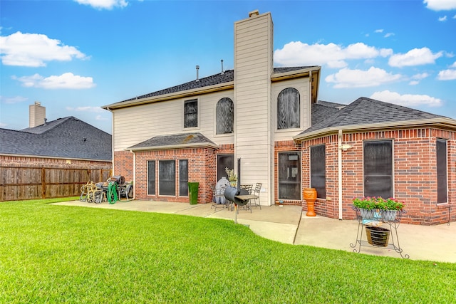 rear view of property with a lawn and a patio