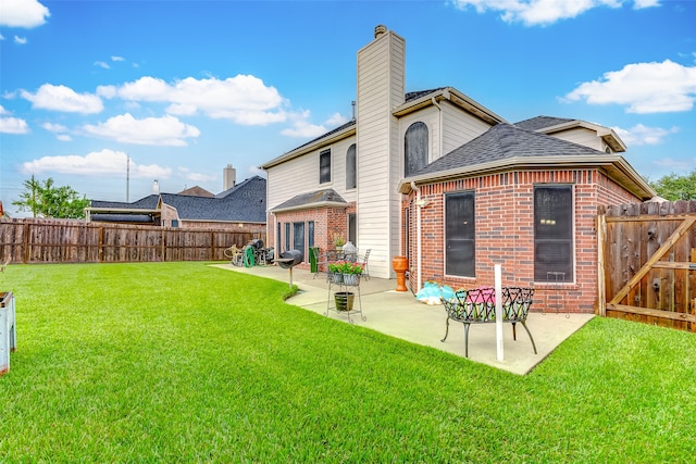 rear view of property with a patio area and a lawn