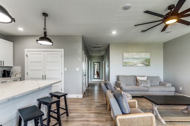 living room featuring a textured ceiling, hardwood / wood-style flooring, and ceiling fan