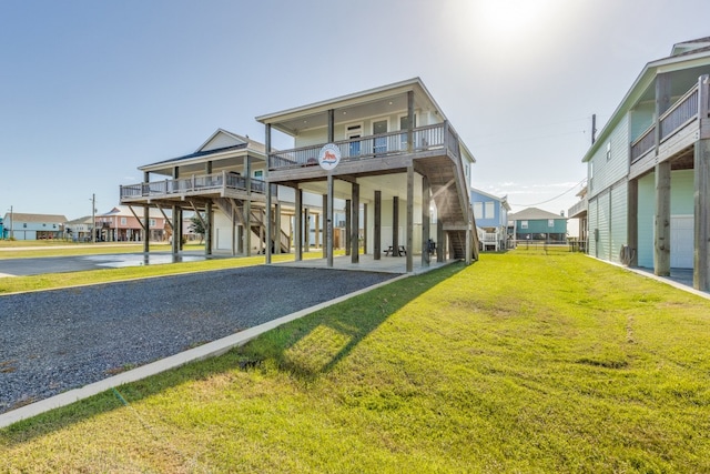 exterior space with a carport, a balcony, and a front lawn