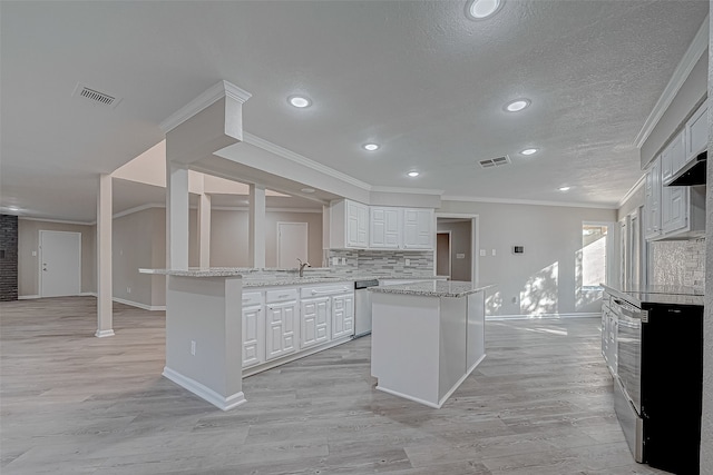 kitchen with a center island, stainless steel dishwasher, crown molding, light hardwood / wood-style floors, and white cabinets