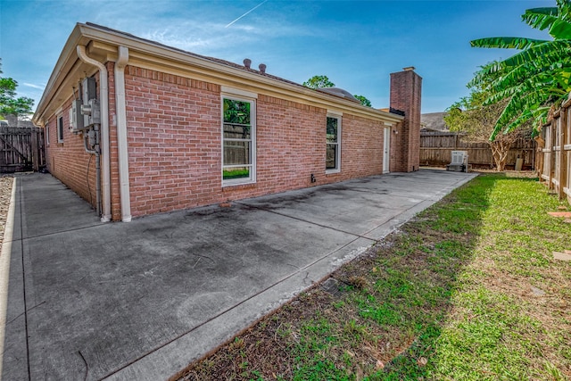 view of side of home with a yard and a patio area