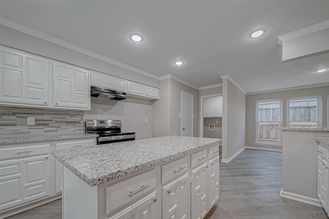 kitchen with a center island, stainless steel range with electric cooktop, extractor fan, white cabinets, and ornamental molding