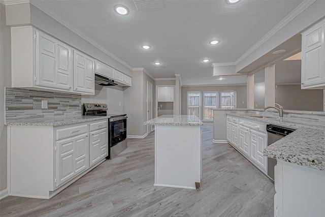 kitchen featuring light stone countertops, stainless steel appliances, white cabinetry, and a kitchen island