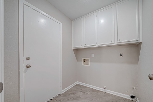 laundry area featuring hookup for an electric dryer, hookup for a washing machine, cabinets, light hardwood / wood-style flooring, and hookup for a gas dryer