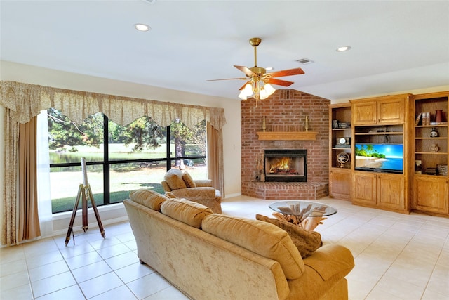 tiled living room featuring vaulted ceiling, a brick fireplace, and ceiling fan