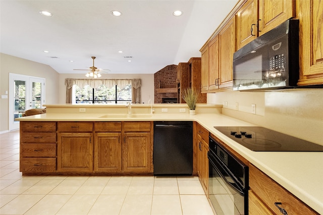 kitchen featuring kitchen peninsula, vaulted ceiling, sink, black appliances, and light tile patterned flooring