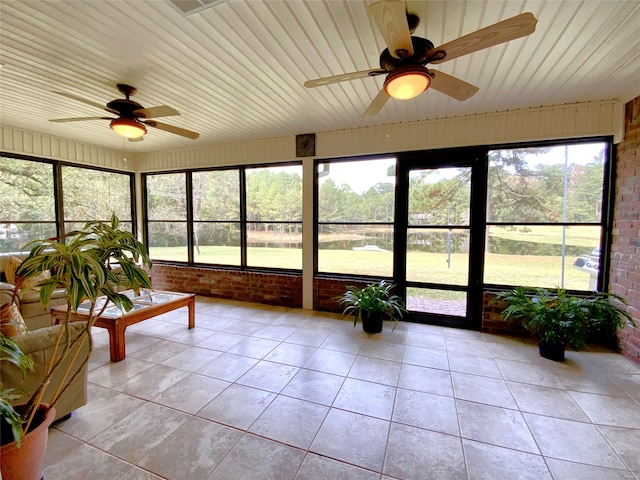 unfurnished sunroom featuring ceiling fan