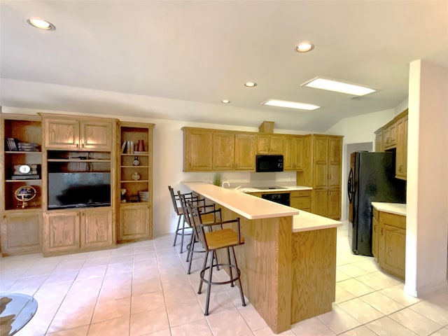 kitchen featuring black appliances, a breakfast bar, light tile patterned flooring, and kitchen peninsula