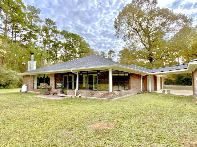 rear view of property with a lawn, area for grilling, and a patio