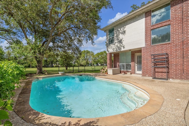 view of swimming pool with a patio area and a diving board