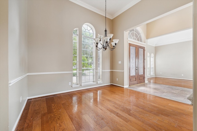 interior space featuring french doors, ornamental molding, a notable chandelier, and hardwood / wood-style flooring