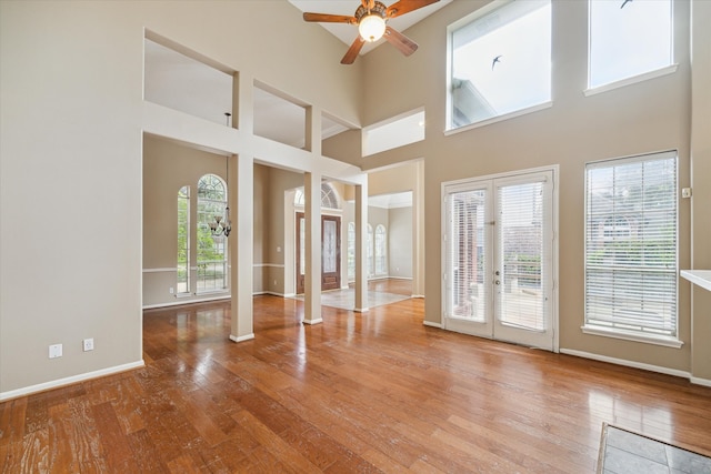 interior space featuring ornate columns, a wealth of natural light, hardwood / wood-style floors, and a high ceiling