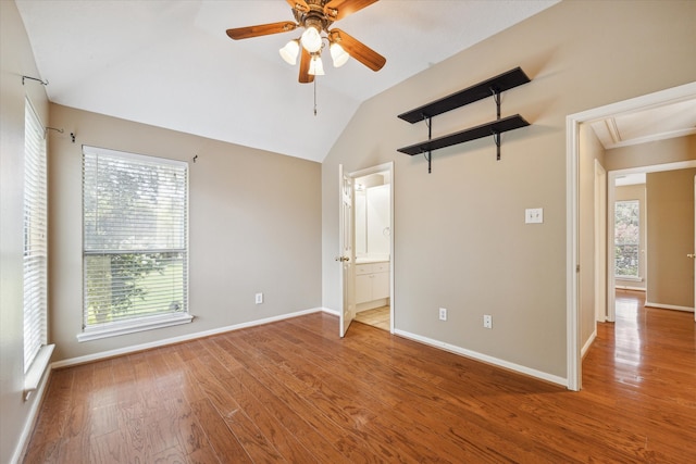 unfurnished bedroom featuring light hardwood / wood-style floors, ensuite bath, multiple windows, and lofted ceiling