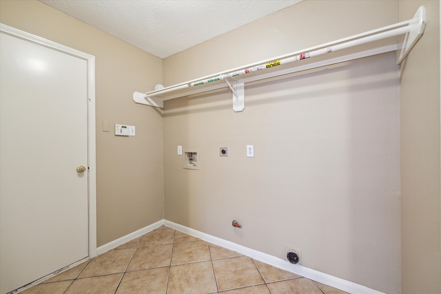 laundry area with washer hookup, a textured ceiling, electric dryer hookup, hookup for a gas dryer, and light tile patterned flooring