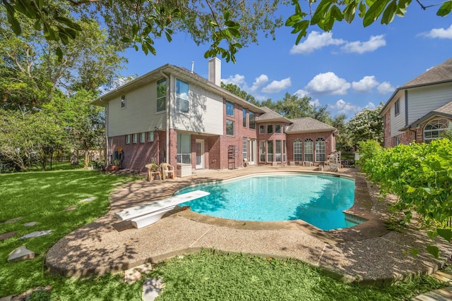 view of pool featuring a patio, a diving board, and a lawn