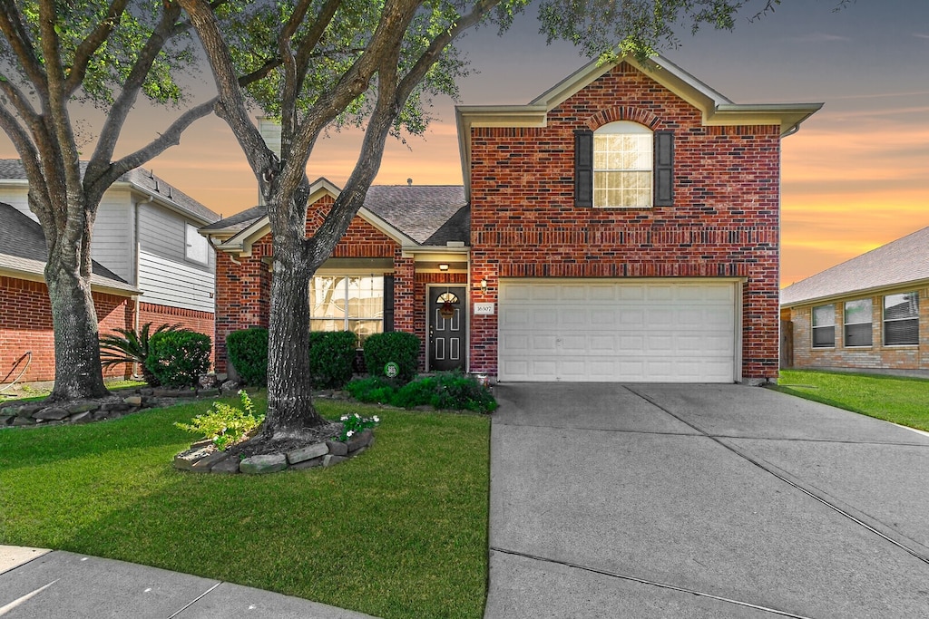 view of front property featuring a garage and a lawn