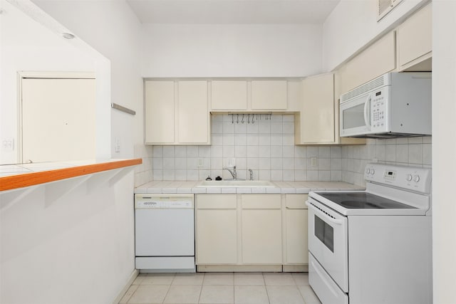 kitchen featuring tile countertops, white appliances, sink, decorative backsplash, and light tile patterned flooring