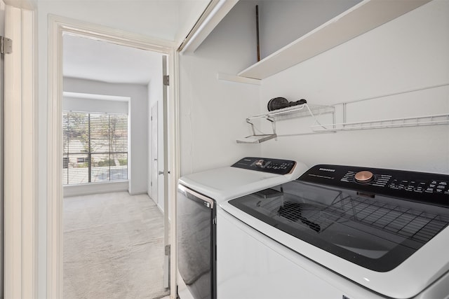 laundry area with washing machine and clothes dryer and light colored carpet