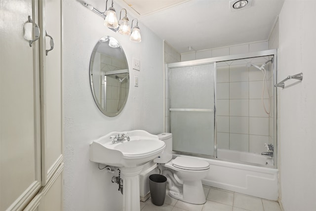 full bathroom featuring tile patterned floors, toilet, enclosed tub / shower combo, and sink