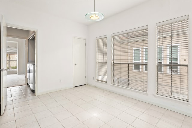 unfurnished room with washer and dryer and light tile patterned floors