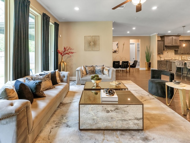 living room with ceiling fan, light hardwood / wood-style floors, and crown molding