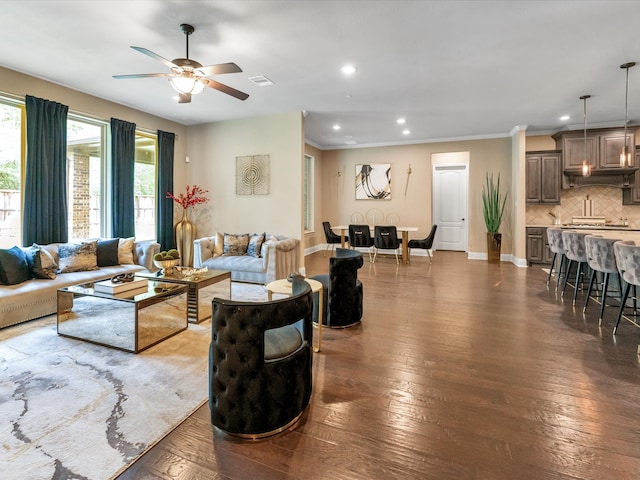 living room featuring ceiling fan, dark hardwood / wood-style floors, and ornamental molding