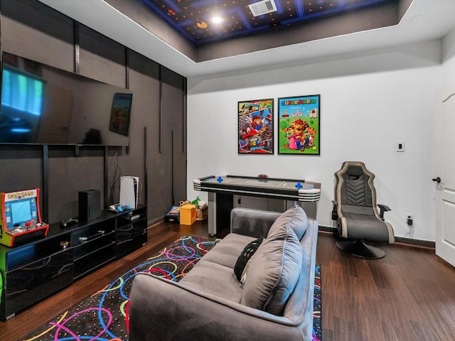 living room featuring a raised ceiling and dark hardwood / wood-style flooring