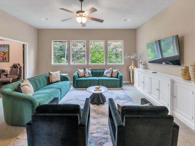 carpeted living room featuring a wealth of natural light and ceiling fan