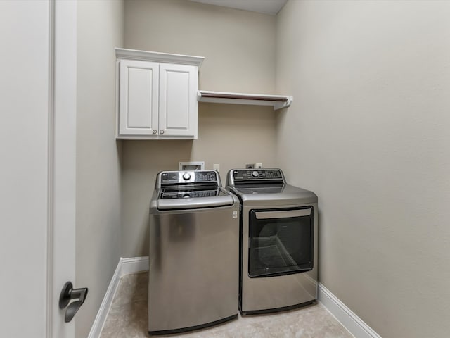 laundry area featuring washer and clothes dryer and cabinets