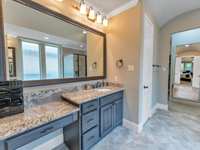 bathroom with vanity, a shower with shower door, and ornamental molding